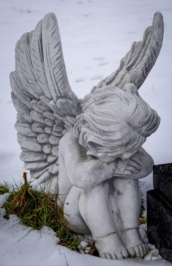 Sitting angel with head bowed in grief