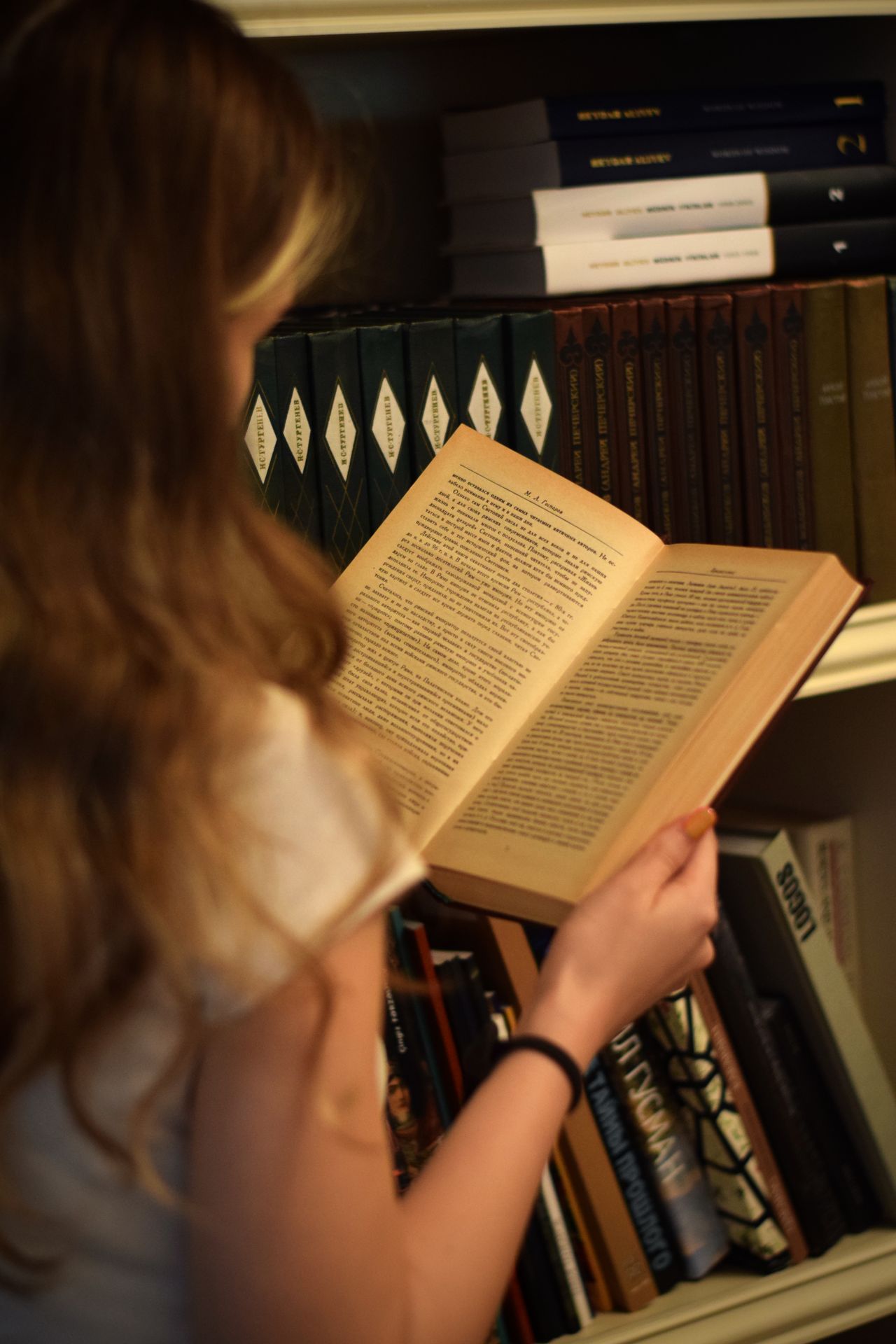 Woman reading book with view over should to open book